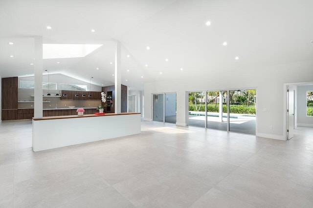 unfurnished living room featuring high vaulted ceiling