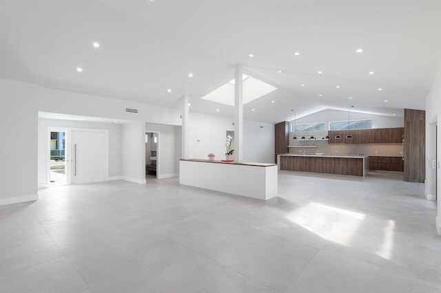 unfurnished living room with high vaulted ceiling