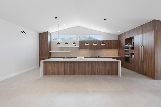 kitchen with hanging light fixtures, a kitchen island with sink, lofted ceiling, and tasteful backsplash