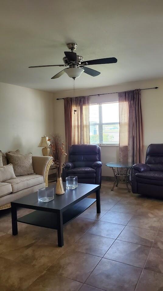 living room featuring tile patterned flooring and a ceiling fan