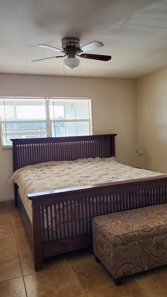 tiled bedroom featuring a ceiling fan