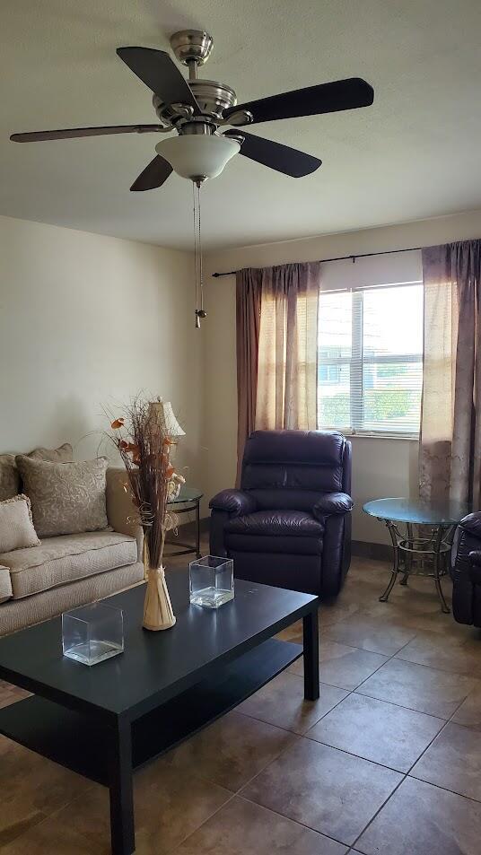 living room featuring tile patterned flooring and ceiling fan