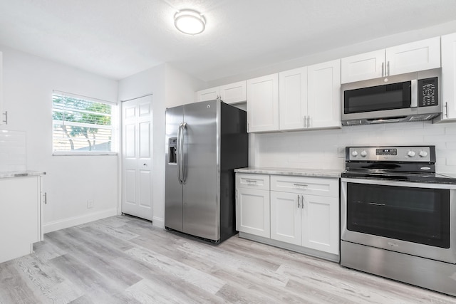 kitchen with light wood-type flooring, white cabinetry, and stainless steel appliances