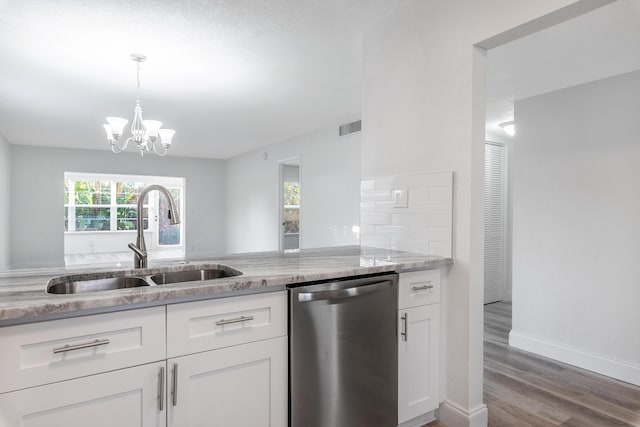 kitchen featuring stainless steel dishwasher, sink, hardwood / wood-style flooring, a chandelier, and white cabinetry