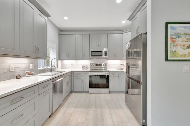 kitchen featuring stainless steel appliances, gray cabinets, and tasteful backsplash