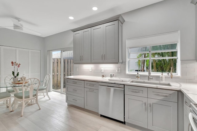 kitchen with decorative backsplash, gray cabinets, stainless steel dishwasher, and ceiling fan