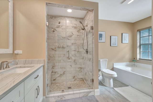 full bathroom featuring toilet, hardwood / wood-style floors, vanity, and shower with separate bathtub