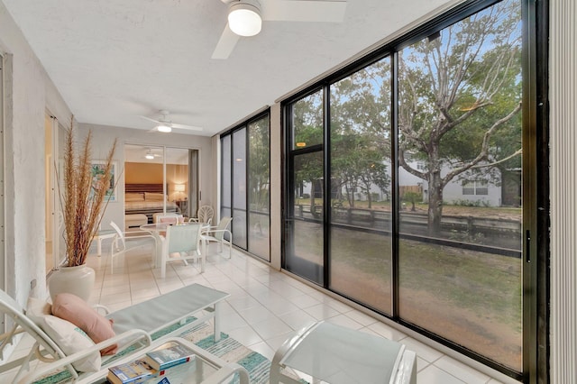 unfurnished sunroom with ceiling fan