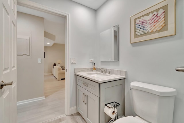 bathroom featuring wood-type flooring, vanity, and toilet