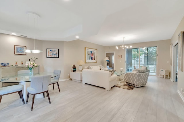 living room featuring a chandelier and light wood-type flooring