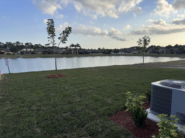 view of yard with a water view and central AC unit