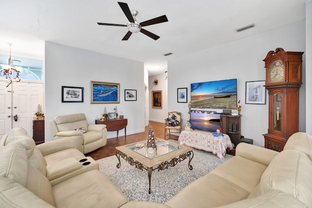 living room with wood-type flooring and ceiling fan with notable chandelier