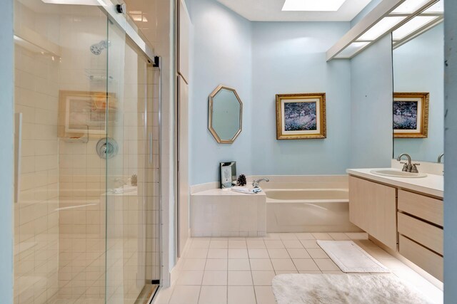 bathroom featuring tile patterned floors, vanity, independent shower and bath, and a skylight