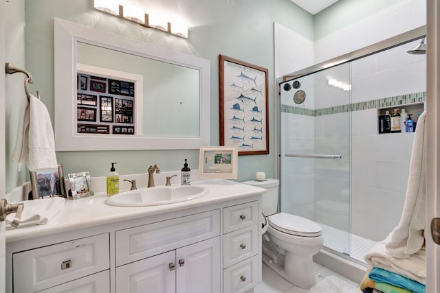 bathroom featuring vanity, a shower with shower door, and toilet