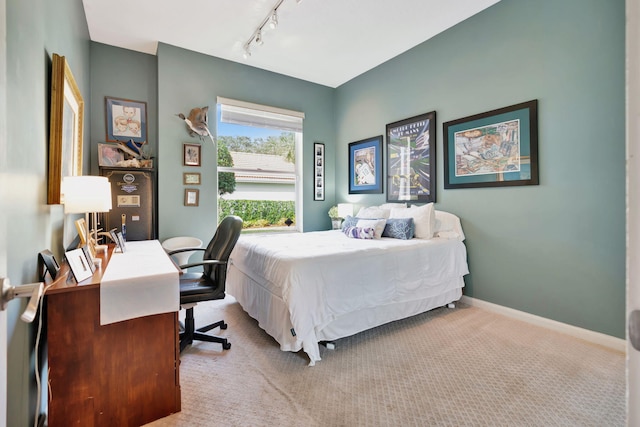 carpeted bedroom featuring rail lighting