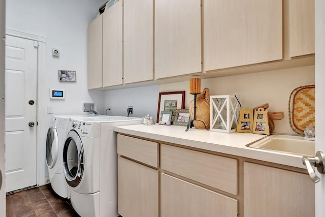 washroom featuring cabinets, washing machine and dryer, and sink