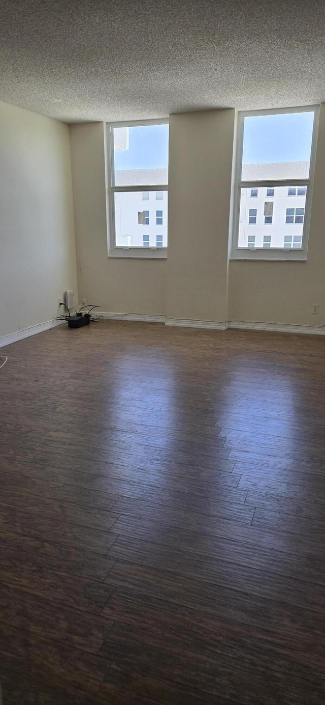1149 Hillsboro Mile Unit 908, Hillsboro Beach, FL 33062 - unfurnished room with plenty of natural light, wood finished floors, a textured ceiling, and baseboards