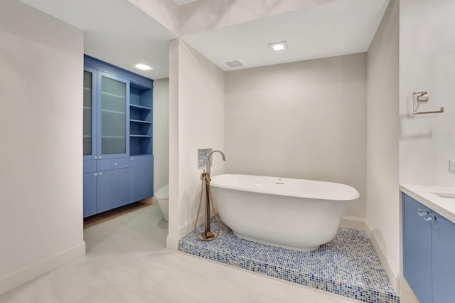 bathroom with vanity, built in features, a bathtub, and toilet