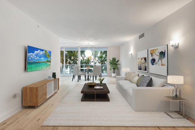 living room with expansive windows and light wood-type flooring