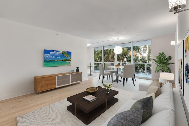 living room with light wood-type flooring and a wall of windows