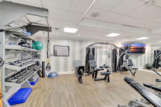 gym featuring wood-type flooring and a drop ceiling