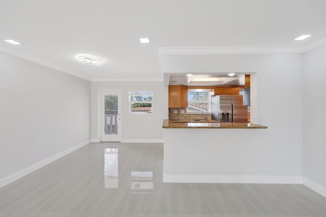 unfurnished living room featuring ornamental molding and sink