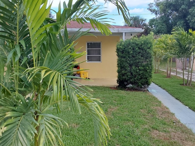 view of side of home with a yard