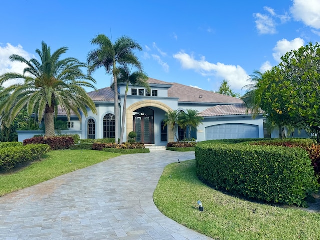 view of front of property featuring french doors, a front yard, and a garage