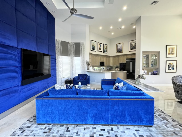 living room featuring a towering ceiling and ceiling fan