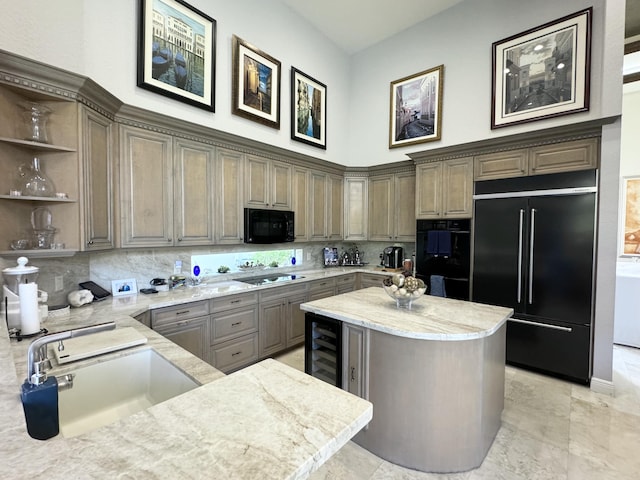 kitchen with light stone countertops, beverage cooler, sink, black appliances, and a center island