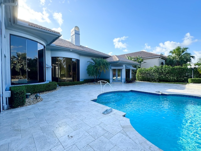 view of pool featuring french doors and a patio area