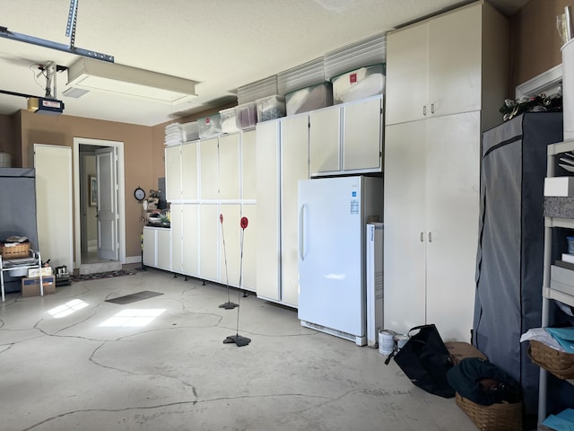 garage with a garage door opener and white refrigerator