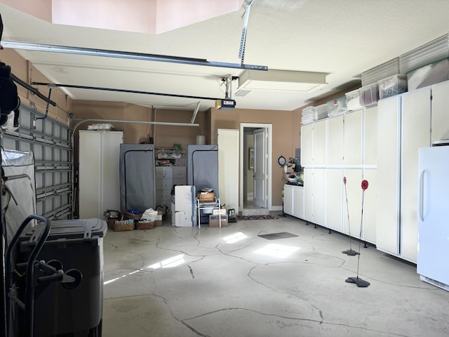 garage featuring white fridge and a garage door opener