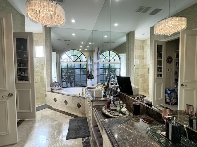 bathroom with vaulted ceiling, independent shower and bath, tile walls, and an inviting chandelier