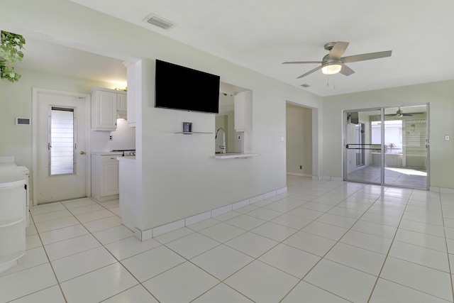 empty room featuring ceiling fan, sink, and light tile patterned floors