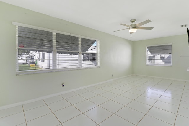 tiled spare room featuring ceiling fan