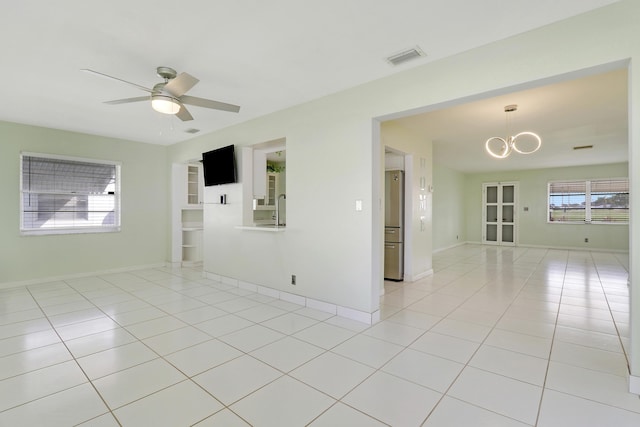 spare room with ceiling fan with notable chandelier, light tile patterned floors, and sink