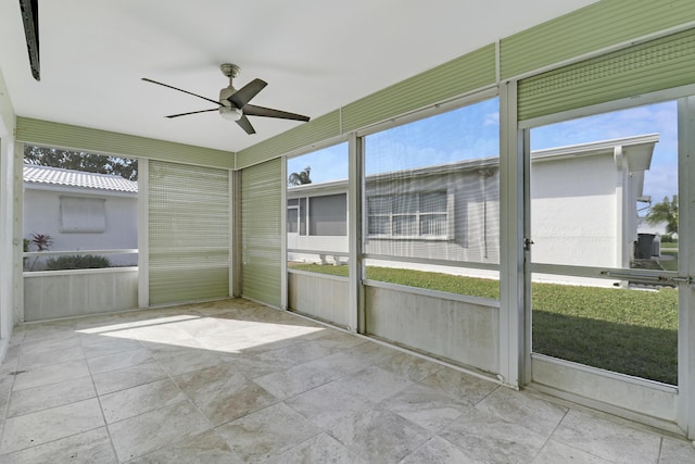 unfurnished sunroom with ceiling fan