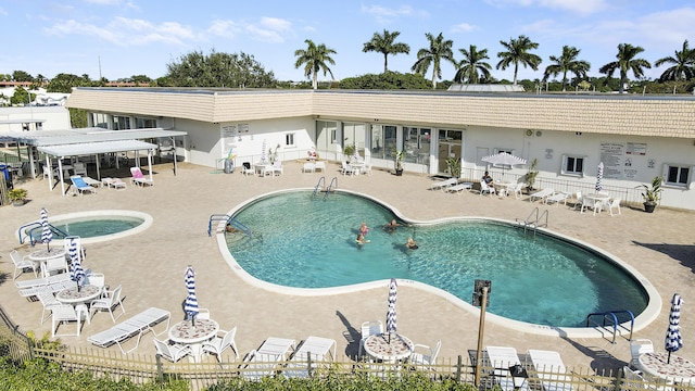 view of swimming pool featuring a community hot tub and a patio