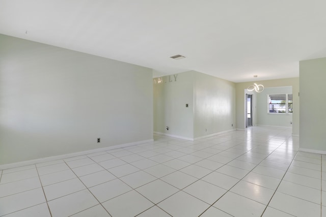 tiled empty room with a notable chandelier