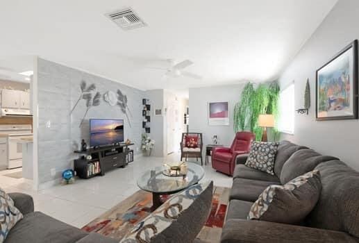 living room featuring ceiling fan and light tile patterned floors