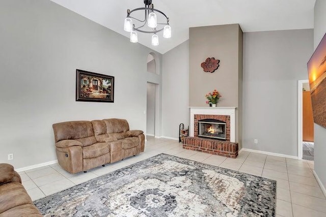 tiled living room featuring a fireplace, an inviting chandelier, and lofted ceiling