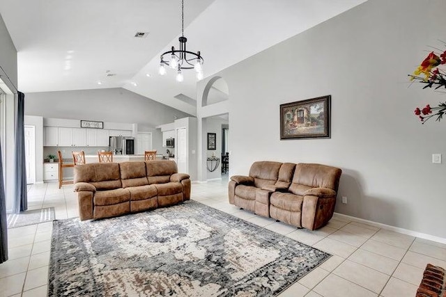 living room with an inviting chandelier, light tile patterned floors, and vaulted ceiling