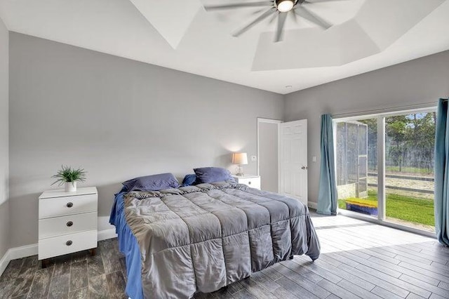 bedroom with dark hardwood / wood-style floors, a raised ceiling, and ceiling fan