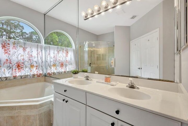 bathroom featuring vanity and independent shower and bath