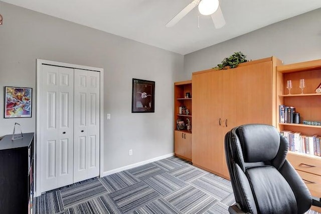 carpeted home office featuring ceiling fan