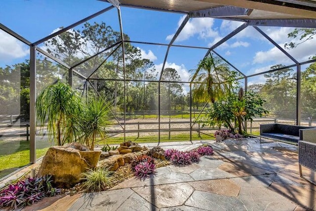 view of patio featuring glass enclosure