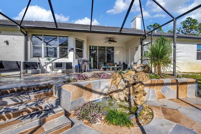 rear view of house with a patio area, ceiling fan, and glass enclosure