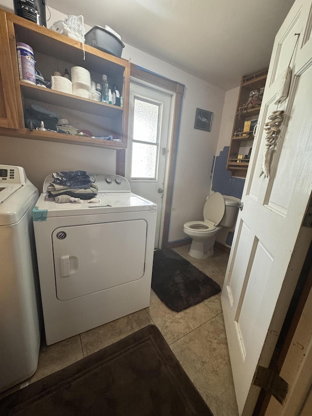 laundry area featuring washer and clothes dryer and light tile patterned flooring