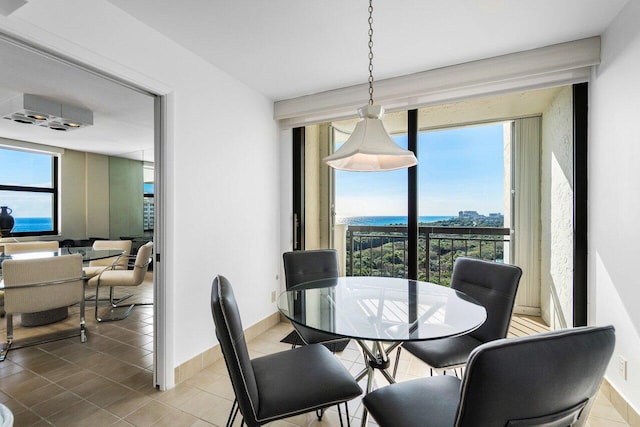 dining room featuring tile patterned flooring and a water view